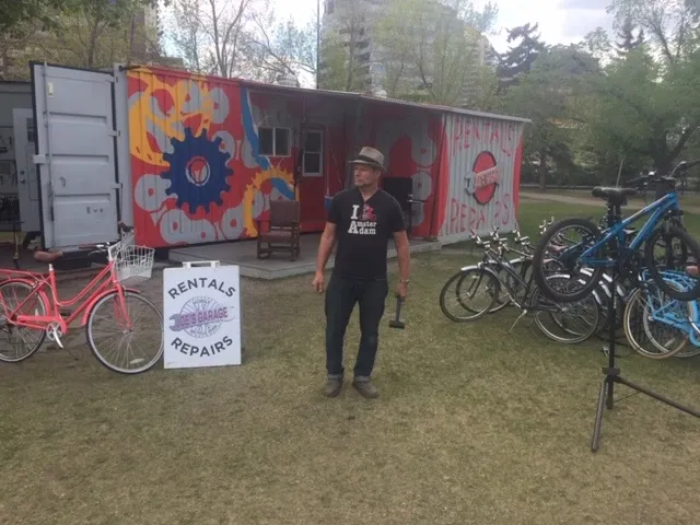 Joe standing in front of the painted shipping container with rental fleet